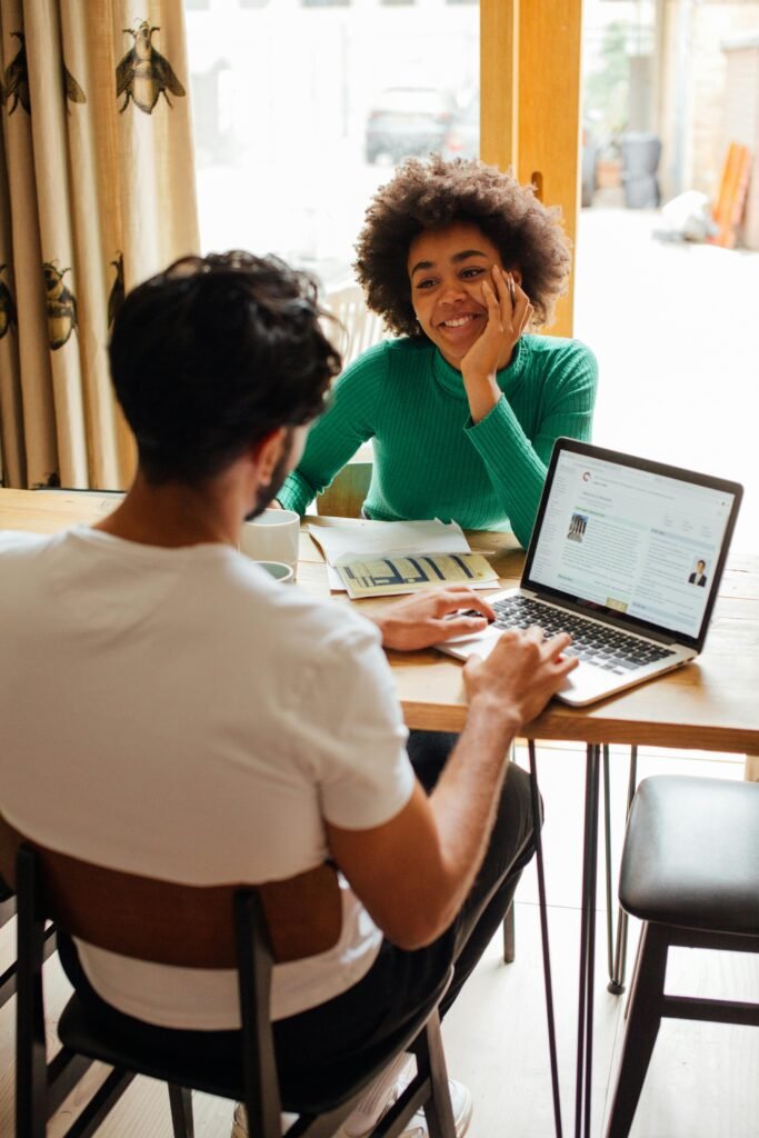 two people at a table, with laptops